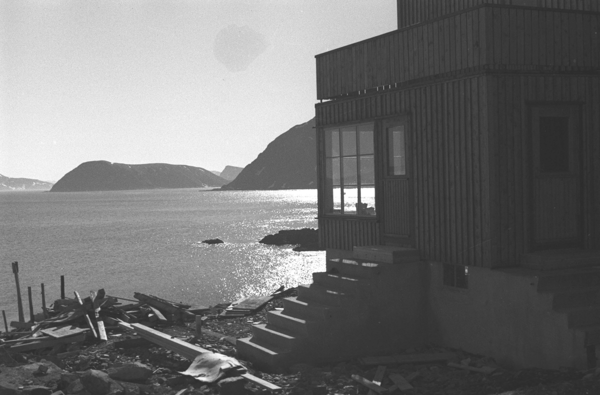 Gjenreisning. Honningsvåg. Inngangen til et nybygd bolighus. Byggemateriale nedenfor huset. 1946/47.