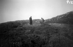 To personer sitter på Kjempegrefthaugen på Skomsøyvågen i Sm