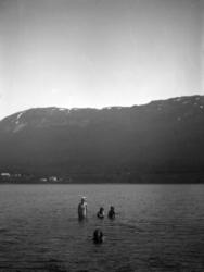 Tre barn og en kvinne er ute å bader i sjøen, trolig i Eidsv