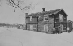 To menn står ved hovedhuset på setra Pustbakken