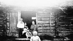 Kvinne og barn i døråpning seterstue