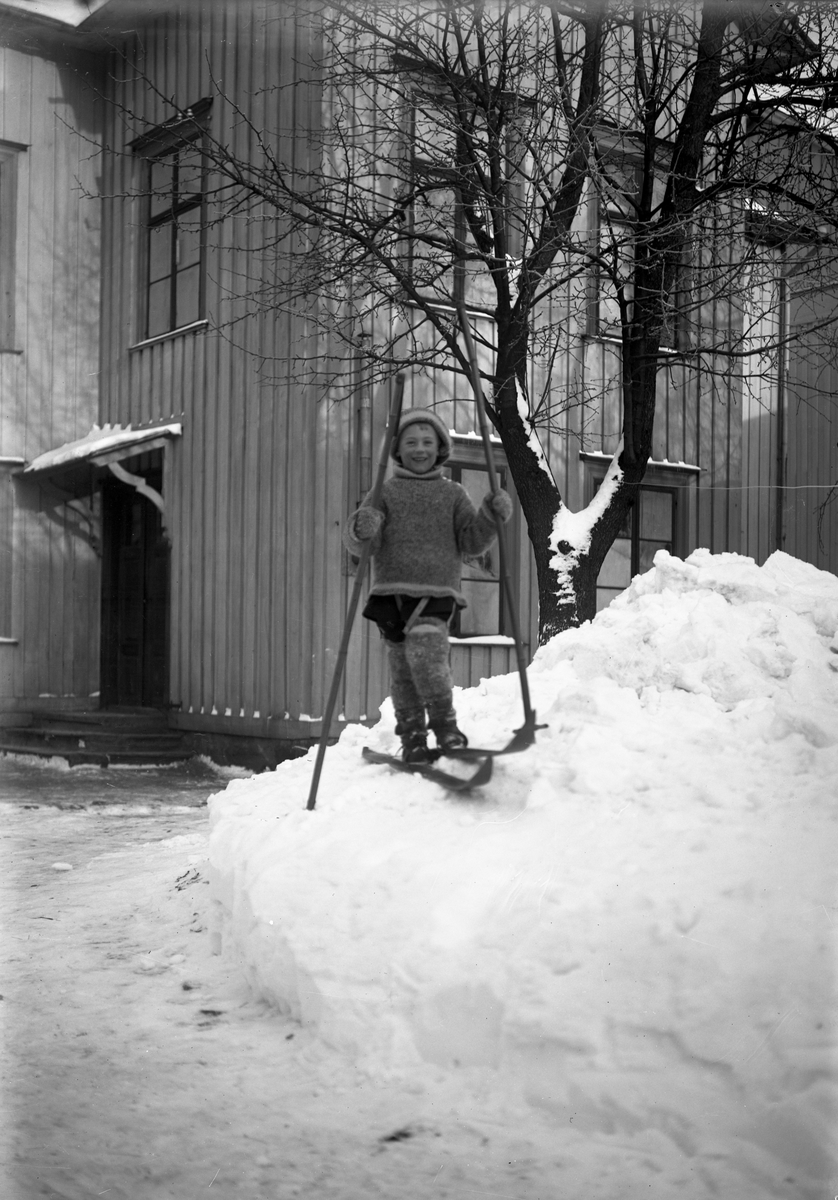 Pojke på skidor. Bilden togs troligen inne på fotografens gård på Södra Klaragatan 2.