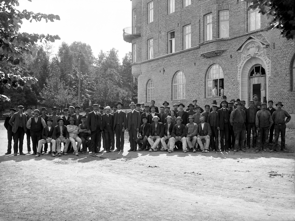Arbetsstyrkan samlad utanför det nybyggda sparbankshuset vid Skillerälven i Filipstad år 1909.
