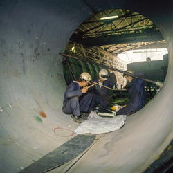 Sveisearbeid - tre menn ser på tegning