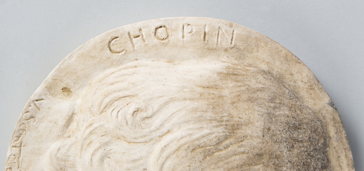 Relieff av Frederic Chopins hode i profil (høyre). 