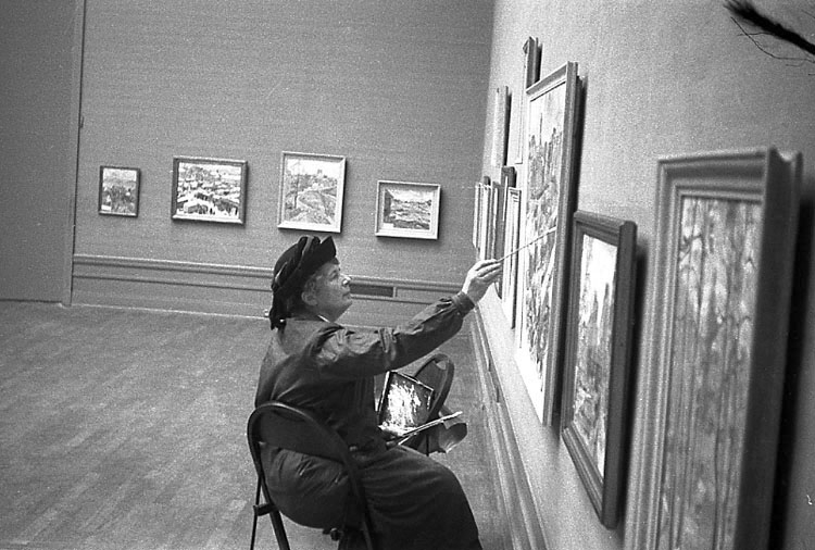 Utställningsarbete på Smålands museum. Foto från Ingegerd Beskows (1887-1978) utställning. 
Konstnärinnan målar något på en av tavlorna.