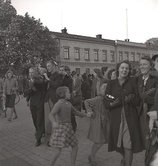 Studenterna 1940. 31/5 - 1/6. En manlig student bärs av sina kompisar längs Stortorget. I bakgrunden syns Residenset.