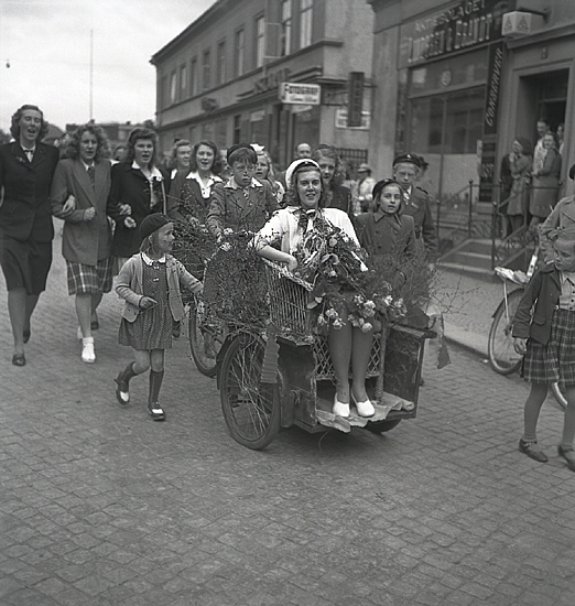 Studentfinal, 1944. 
En kvinnlig student körs iväg på cykelkärra längs Storgatan, av sina kamrater. I bakgrunden syns P.N. Perssons fastighet och "Lindgren & Brandt."

Angående avgångsklassen 1944 - se "Lärare och Studenter vid Växjö Högre Allmänna Läroverk, 1850-1950" (Växjö 1951), s.174-176, 283.