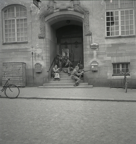 Hemvärnet, 1942. 
Några män i hemvärnsuniform har tagit betäckning vid ingången till
postkontoret i dåv. Post- och Riksbankshuset.