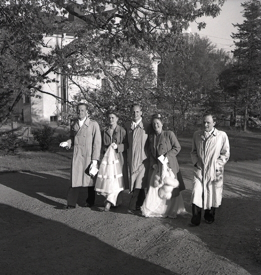 Doktorinnan Tegner, 19/5 1945. 
Bröllopsgäster på väg uppför en bred trädgårdsgång. 
I bakgrunden skymtar ett bostadshus.