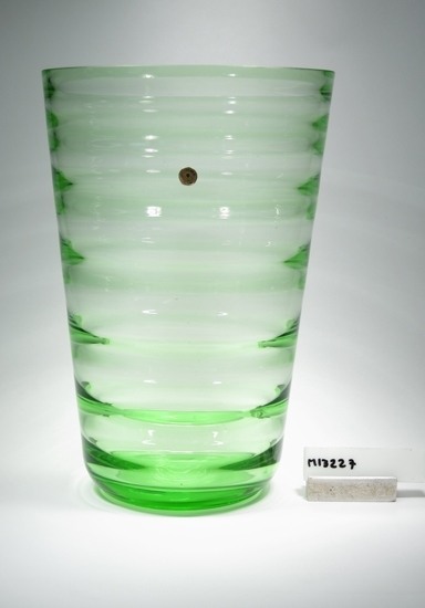 Blomglas.
Beskrivning: Invändigt optikbehandlad.
Färg: Grönt klarglas.
Mått: Ovan anges höjd och diameter. (diameter: 192,5 mm.)
Inskrivet i huvudkatalogen 1943.
Funktion: Vas