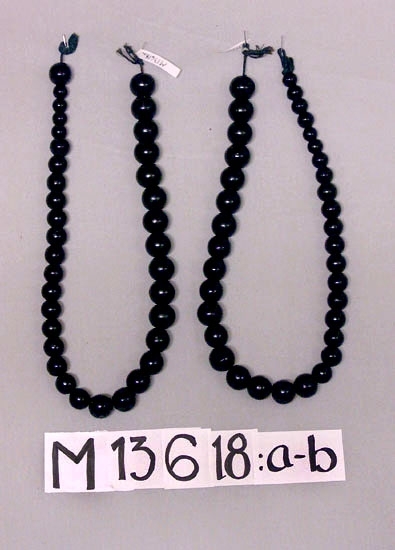 Gardinomtag, bestående av svartlackerade träkulor, uppträdda på en svart snodd. Kulornas diameter varierar från ca 13 till 25 mm.
Mått: längd ca 70 cm. 
Inskrivet i huvudkatalog  1944.