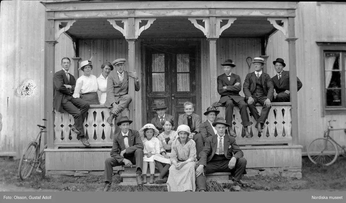 Gruppfoto i trappan av huset och verandan, från 1920-talet.