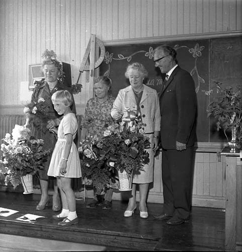 Sista skoldagen i Reaby skola 1962. Lärarna Anna-Lisa Lundin och Ruth Pettersson flankerar städerskan Edith Svan i mitten, alla med blommor i famnen. Flickan och mannen till höger är oidentifierade.