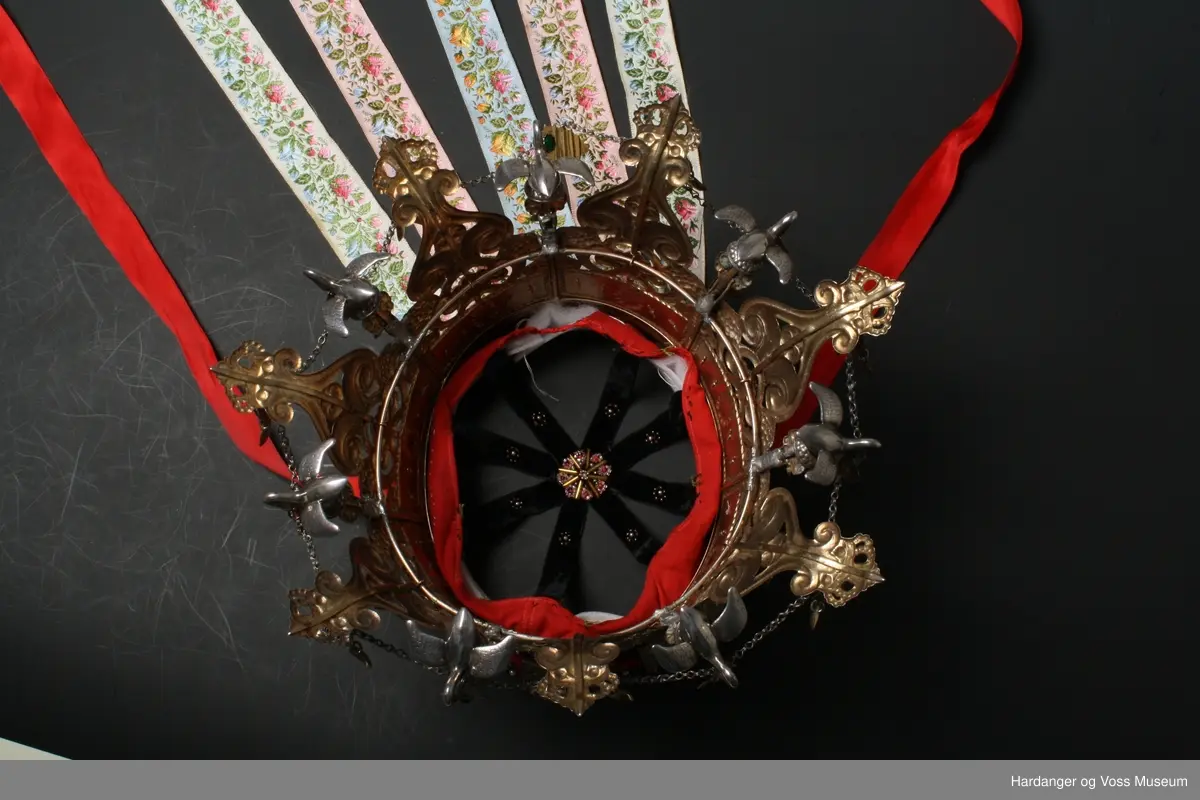 Kruna er kjøpt hjå Hestenes i Bergen, 1935 av Brita Skåltveit. Den er laga av gullsmed Bottelsen i Bergen juni 1890.

Kruna består av 7 stavar som er hengsla saman. 7 svanar er festa over kvar hengsle. Litt usikkert om svanane er av sølv eller tinn.
Underbinding er sydd fast til kruna. Likeså kruneband.