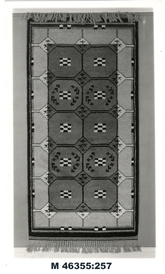 Svartvitt foto av matta.
Flossamatta med geometriskt mönster.

Inskrivet i huvudbok 1983.
Montering/Ram: Ej ramad
