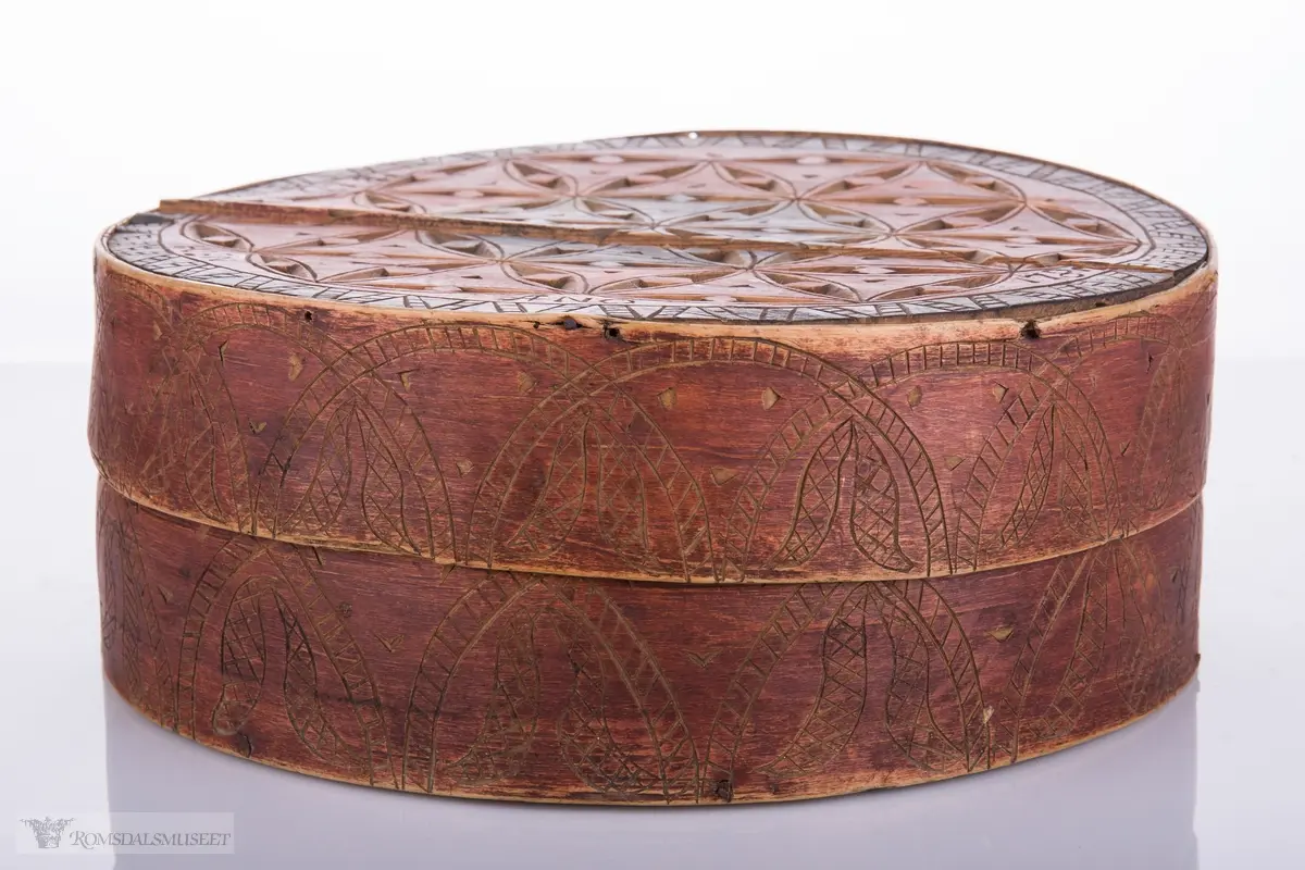 Eit slag seksbladrosemønster på lokk. Bueformede skaverte border på trosken.