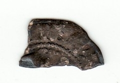 Lite fragment av mynt i halvpenning-størrelse.
