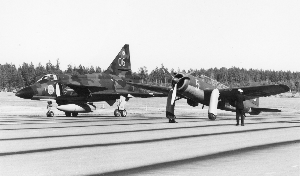 Flygplan AJ 37 märkt 7-06 från F7 Såtenäs och flygplan Saab S 17 nummer 005 står på ett flygfält.