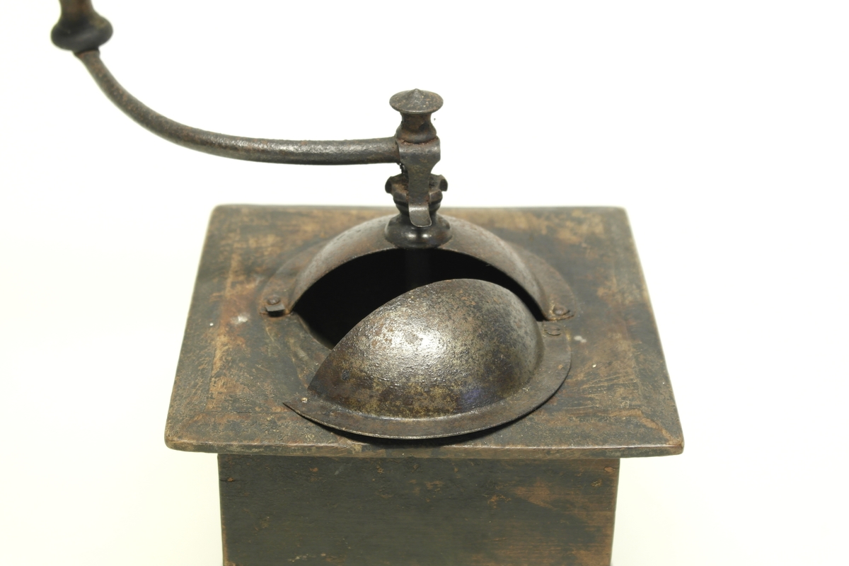 Kaffekvern (a og b) i tre, jern og messing. 
a) Kvadratisk kasse med topplate og bunnplate. Sveiv som går ned til innsatt tannhjul, som kverner kaffebønnene. Klokkeformet deksel som kan åpnes med en klaff som skyves til siden. Messingskilt med stempel.
b) Skuff som samler opp den malte kaffen. Stiftet i hjørner og bunnplate.