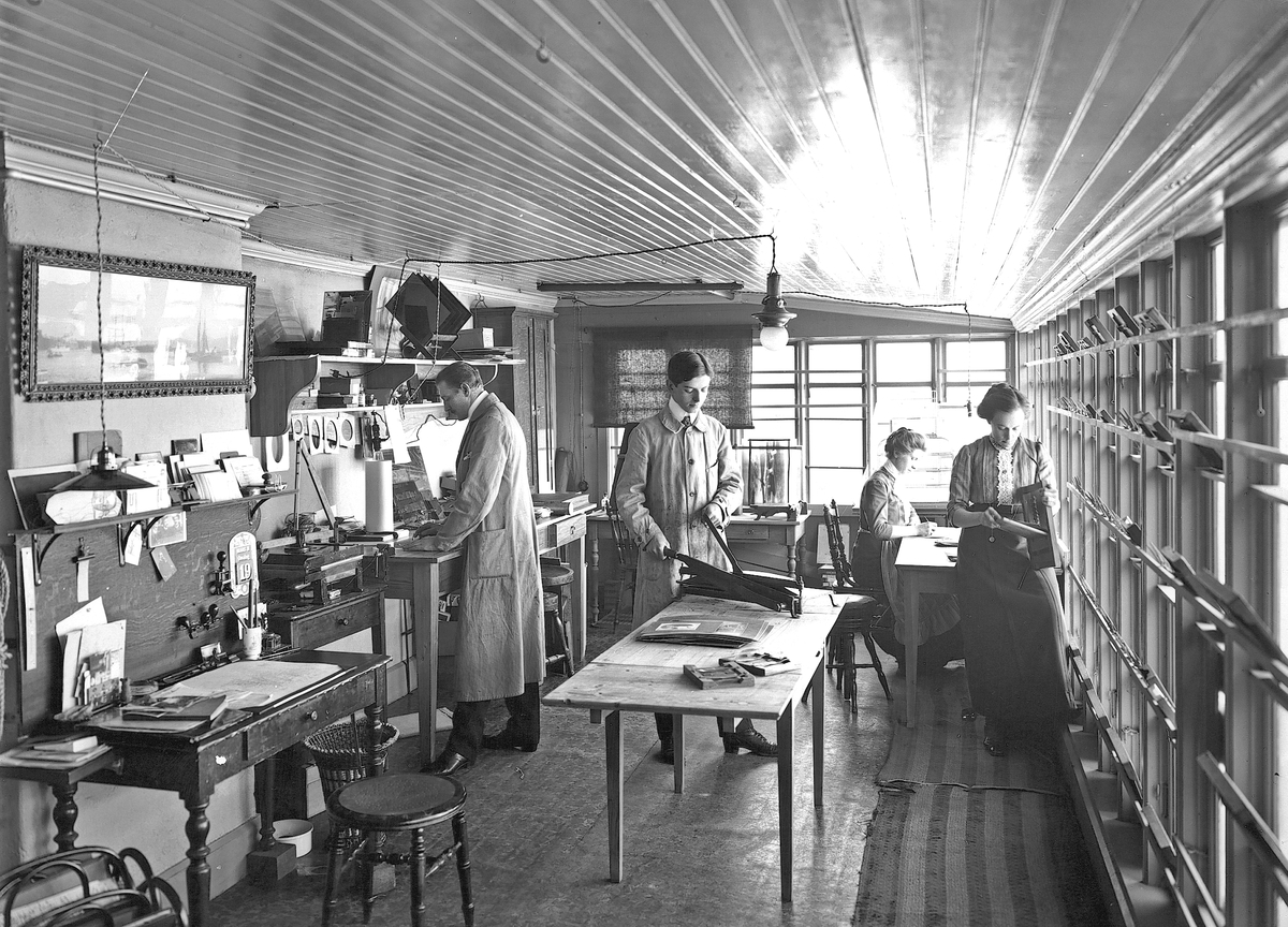Reimers fotografiska ateljé, arbetsrummet. Onsdagen den 19 mars 1913. Till vänster fotograf Gustaf Reimers, i mitten Gunnar Hermansson.