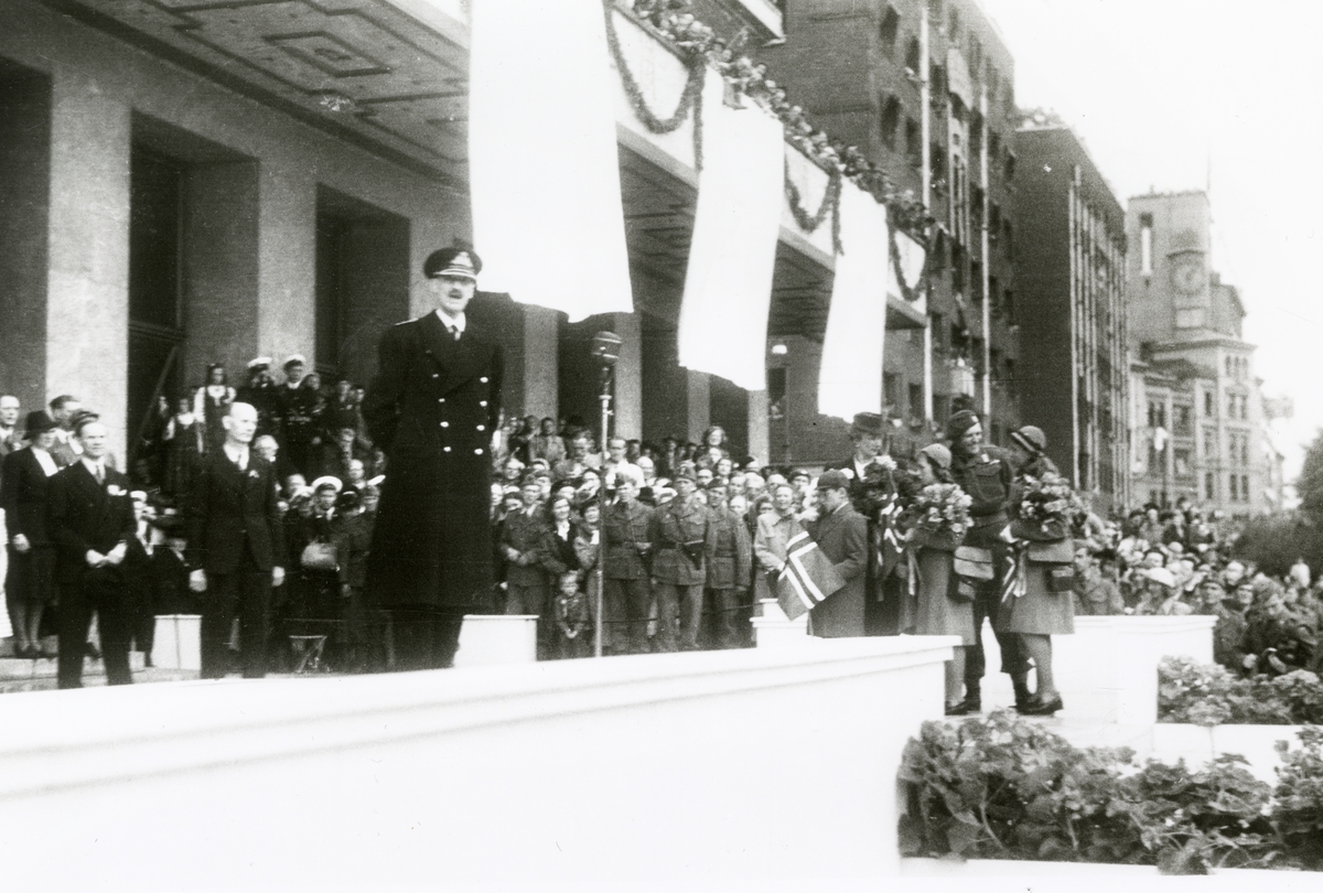Fra Oslo 7. juni 1945.
Kongen kommer tilbake.Kongefamilien samlet foran Rådhuset.Kongen holder tale.