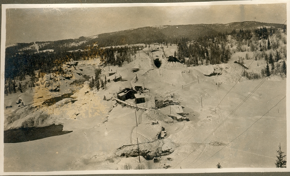 Landskap. Vinter. Skog og fjell. Noen bygninger ved en elv. opplysn: Renfossen under utbygningen 1920-1922.