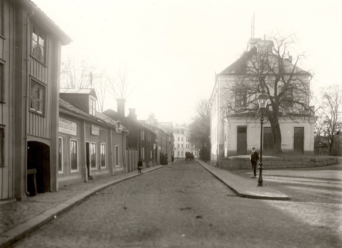 Orig. text: Storgatan från Borggården mot Barnhemsgatan

Östergötlands Velociped-Fabrik i den andra byggnaden vänster i bild.
Den vita byggnaden till höger är Telegraf- och telefonstation.