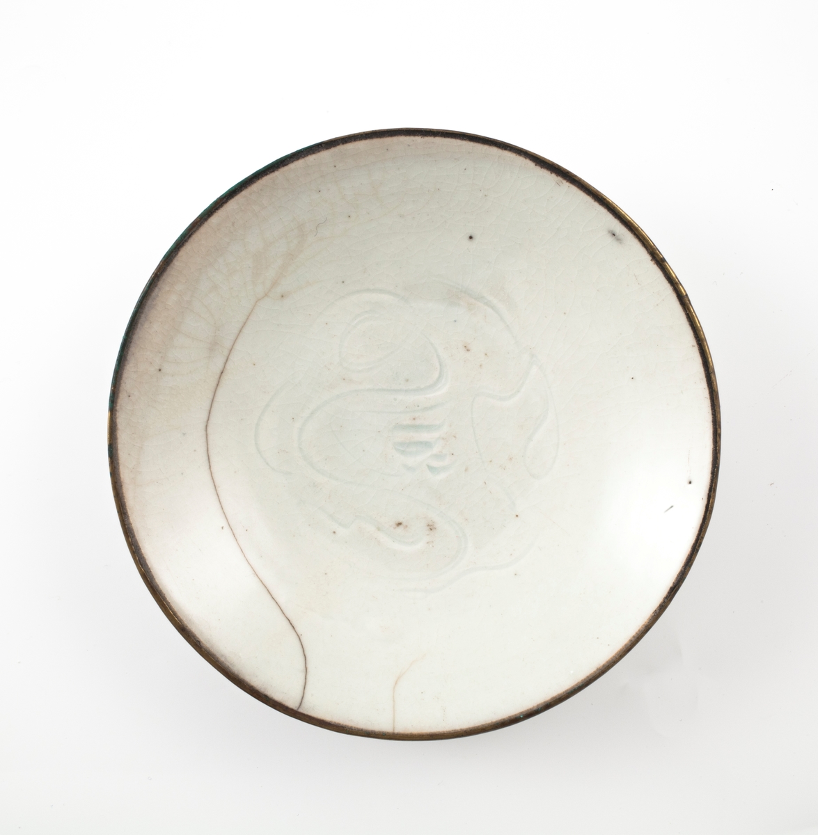 Lav, rund porselensskål med lyseblå celadon. Innrisset et slyngplantemønster i speilet.