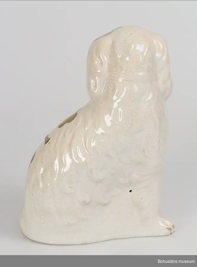 Sammanhör med UM004695

Ur handskrivna katalogen 1957-1958:
Hund av porslin (sittande)
Föremålet av vitt porslin, delvis bronserat. Smärre sprickor på ytan. För övrigt hel.
