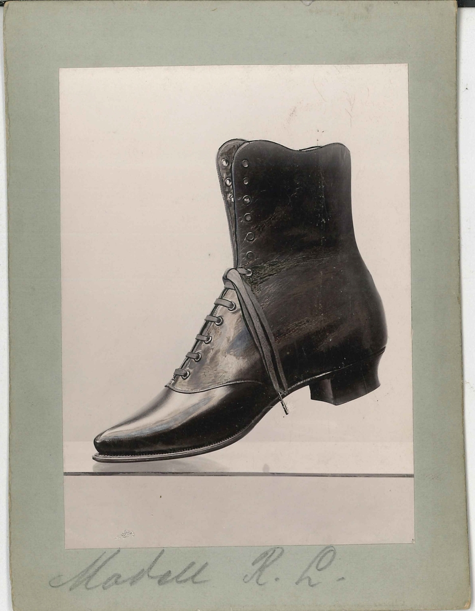 Fotografi av ett skodon. Damkänga med snörning. Modell från sekelskiftet 18-1900.

Använd som reklam på A F Carlssons skofabrik.

Ingår i en samling med 123 stycken kort i kartong.