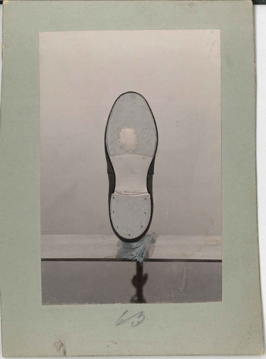 Fotografi av ett skodon. Barnsko. Bild på undersidan av skon.

Använd som reklam på A F Carlssons skofabrik.

Ingår i en samling med 123 stycken kort i kartong.