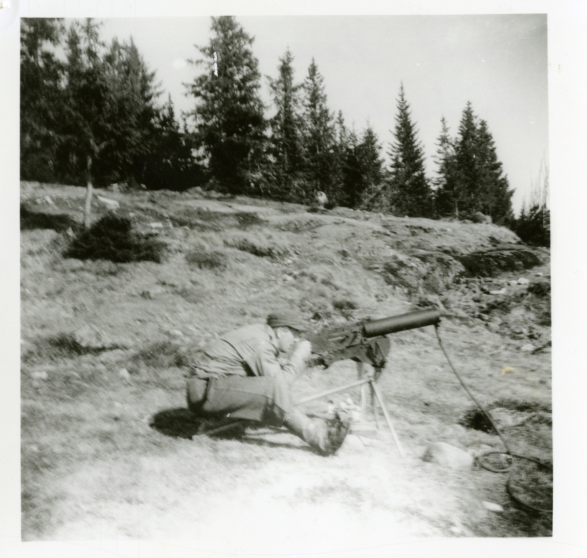 Bjarne Holt-Larsen i Hjemmefronten ved ei mitraljøse, foten er laga av Sigurd Berger, av vannpostrør. HS-kurs i Reinsjødalen, Nysetra i 1944.