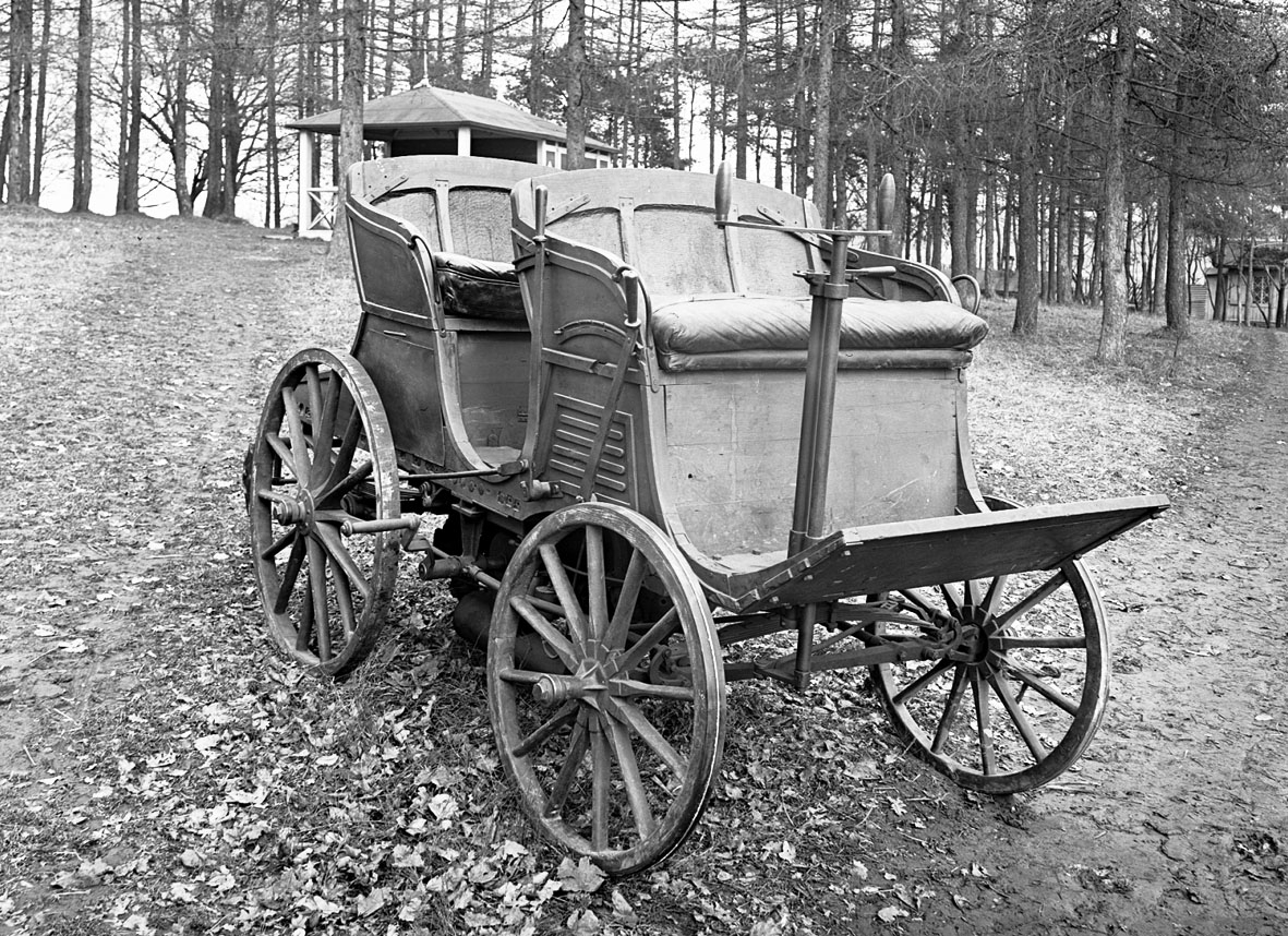 Åkvagn för 4 personer. Den första förbränningsmotordrivna bilen som byggts i Sverige. I detta sista utförande från 1901 ligger en fotogenmotor under vagnsgolvet, vilken startas med vev. Reglage på en styrkolonn under styret, spak för i- och urkoppling av motorn samt handbromsspak på höger sida. Vagnskorg av trä och hjul byggda av C A Carlsson & Söner i Stockholm. Korgen byggd speciellt för bilen och bakhjulen är kraftigt utförda för att tåla att användas som drivhjul.  Tvåcylindrig vattenkyld fotogenmotor. Cirka 5 hästkrafter. Växlar saknas, motorn är omkastningsbar för gång fram eller back. Glödrörständning, värmdes med blåslampa. Totalvikt cirka 600 kg, motorn 200 kg.
Tillbehör: Två medar för körning i snö som kan monteras istället för framhjulen.