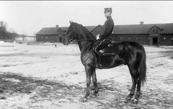 Strömsholmskursen 1916. Ridning på Strömsholm på Stallplan mellan lilla ridhuset (till vänster), officersstallet (till höger), hingstridhuset och hingststallet.