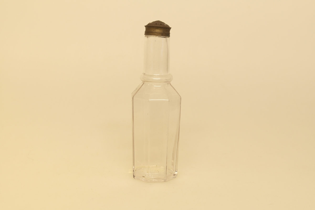 Kryddersett bestående av stativ (a), tre glass (b-e) og skje (f).
A) Krydderstativ av løvtre og støpt messing. Stativet er saget, høvlet, pusset og lakket. Messingkant rundt tre sirkelåpninger. Balusterformet håndtak med ring i messing i midten av stativet. Tre messingbein formet som dyreføtter.
B) Støpt glass med glasspropp (E)
C) Støpt glass med gjennomhullet messingkork
D) Støpt glass
F) Skje i bein som er skåret og pusset