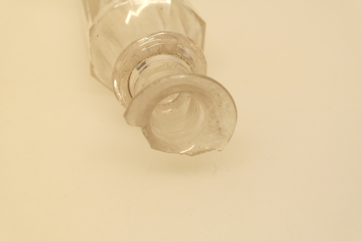 Kryddersett bestående av stativ (a), to flasker (b, c, f) og to glass (d-e).
A) Krydderstativ av tre og støpt messing. Messingkant rundt 4 sirkelåpninger. Fire balusterformede messingbein.
B) Flaske i støpt glass med glasspropp (F)
C) Flaske i støpt glass
D) Støpt glass