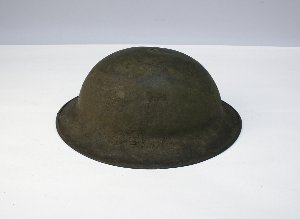 Olivengrønn stålhjelm, modell M/1916 med hakerem av brunt lær.  Trukket innvendig med brunt og svart skinn.  