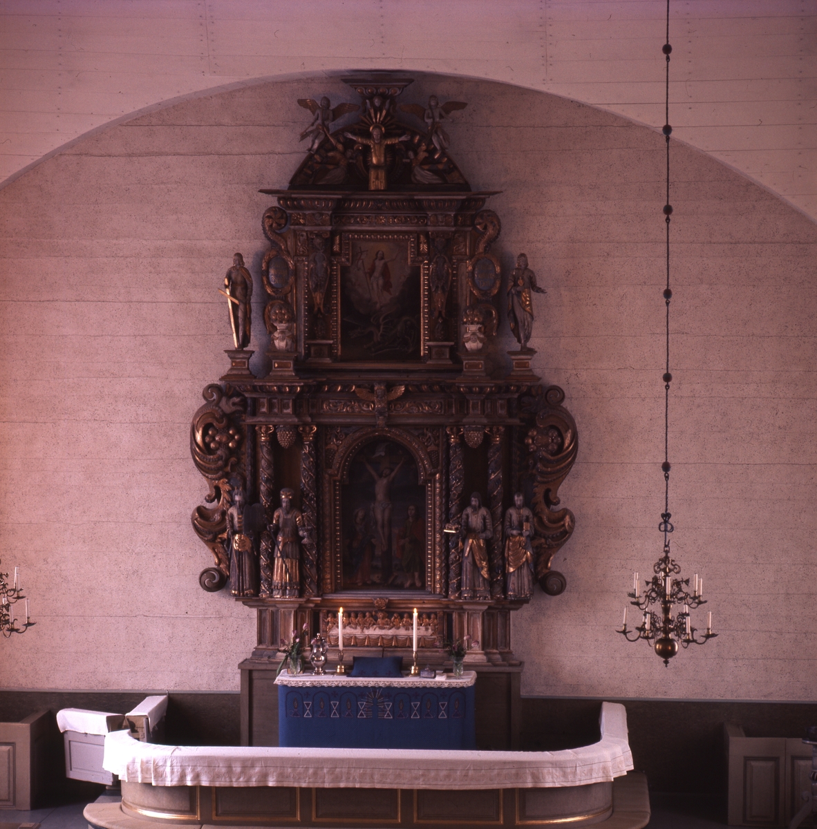 En altaruppsättning med målningar i förgyllda ramar och skulpturer, Solfs kyrka i Finland.