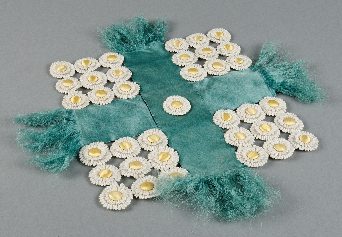 Piedestalsduk av turkosa sidenduschessband och blommor av vita bomullsband med knappar klädda med gult siden.

