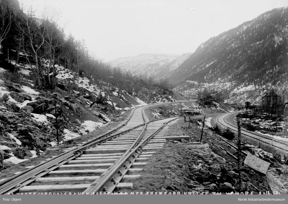 Jernbanespor ved Såheim stasjon (Rjukan stasjon). Sporet går videre til Vemork. Gårder langs Vesetsletta i bakgrunnen.
