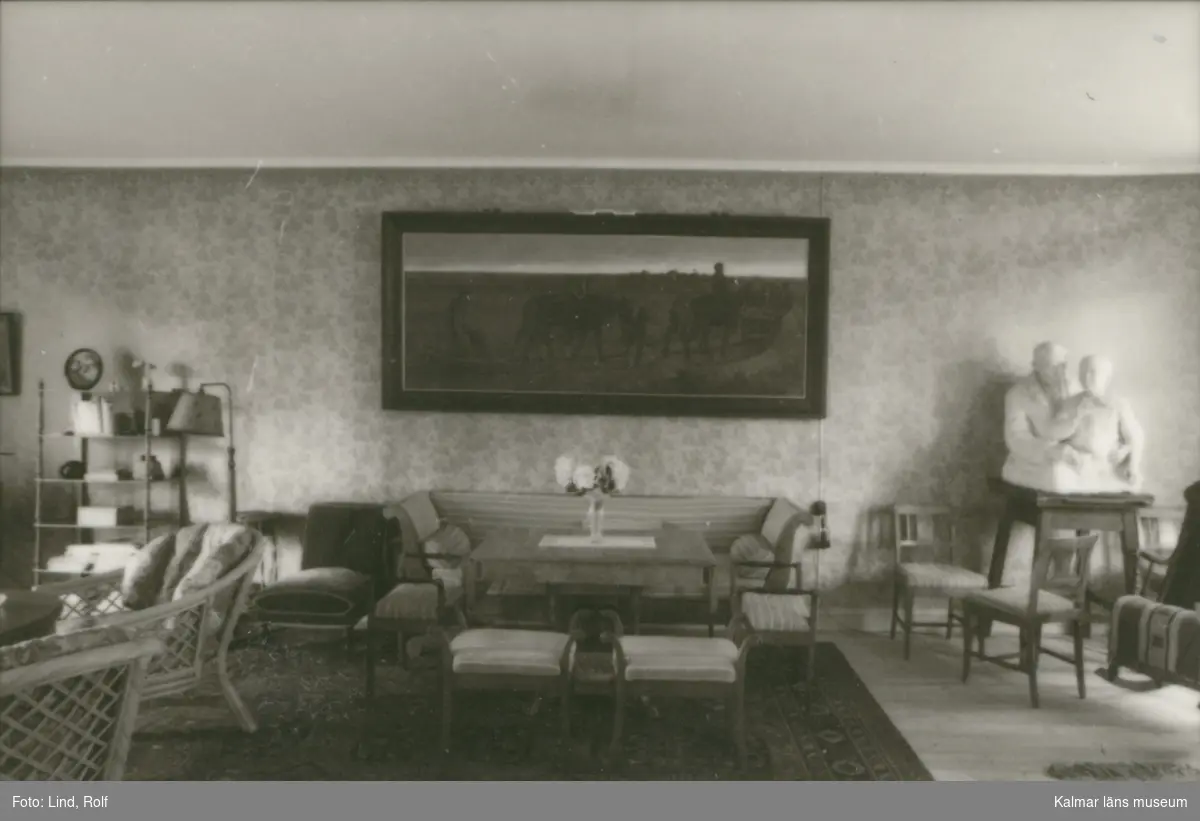En salong i Ekvik 1:1 med bland annat en soffa, en tavla och en skulptur.