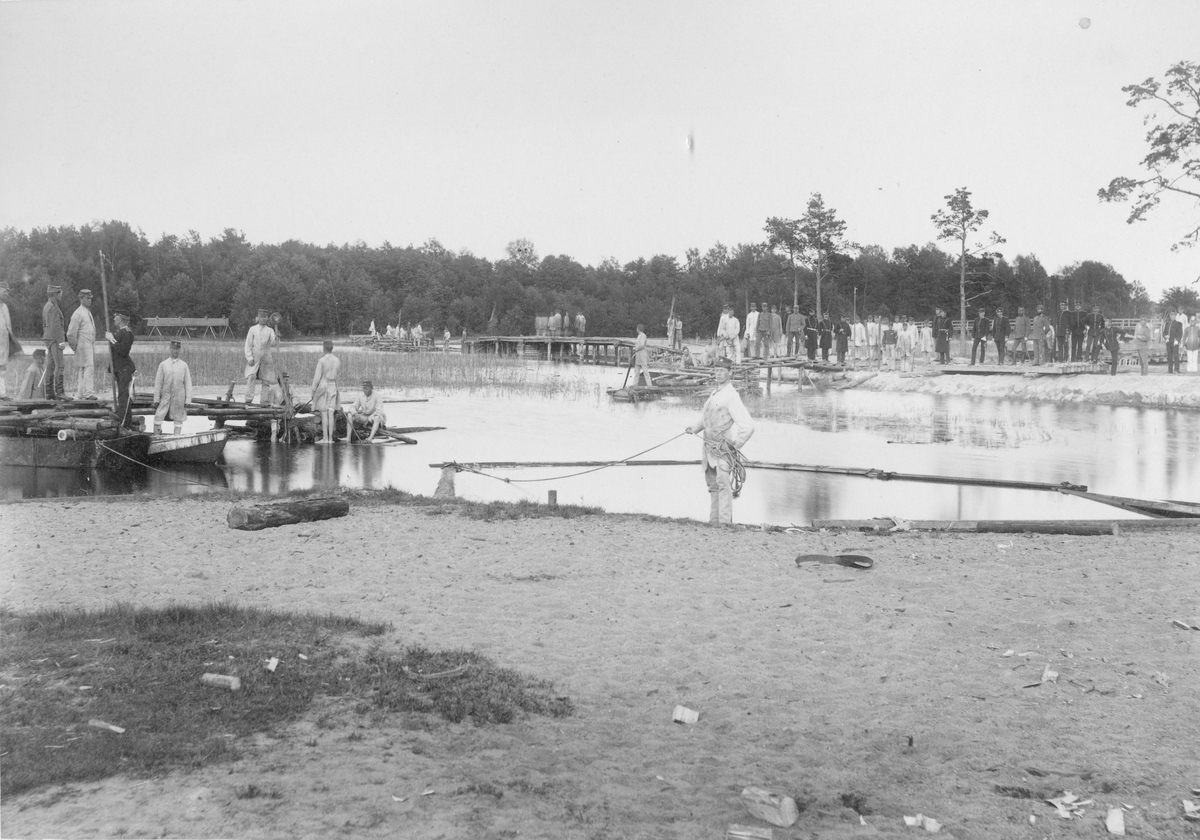 Soldater och officerare från Karlsborgs fästning vid vattendrag.
