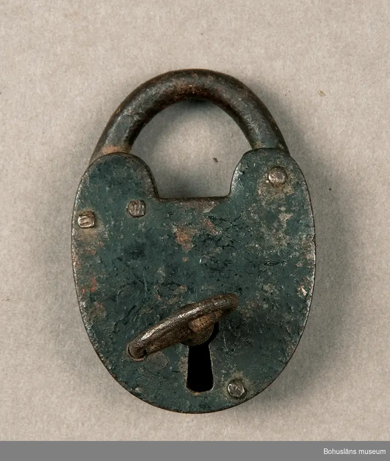 Ur handskrivna katalogen 1957-1958:
Järnlås
Litet hänglås. 
Mått c:a 4,2 x 4,7 cm.
Nyckelns Mått: 3,9 x 2,2.
Låset rostigt.