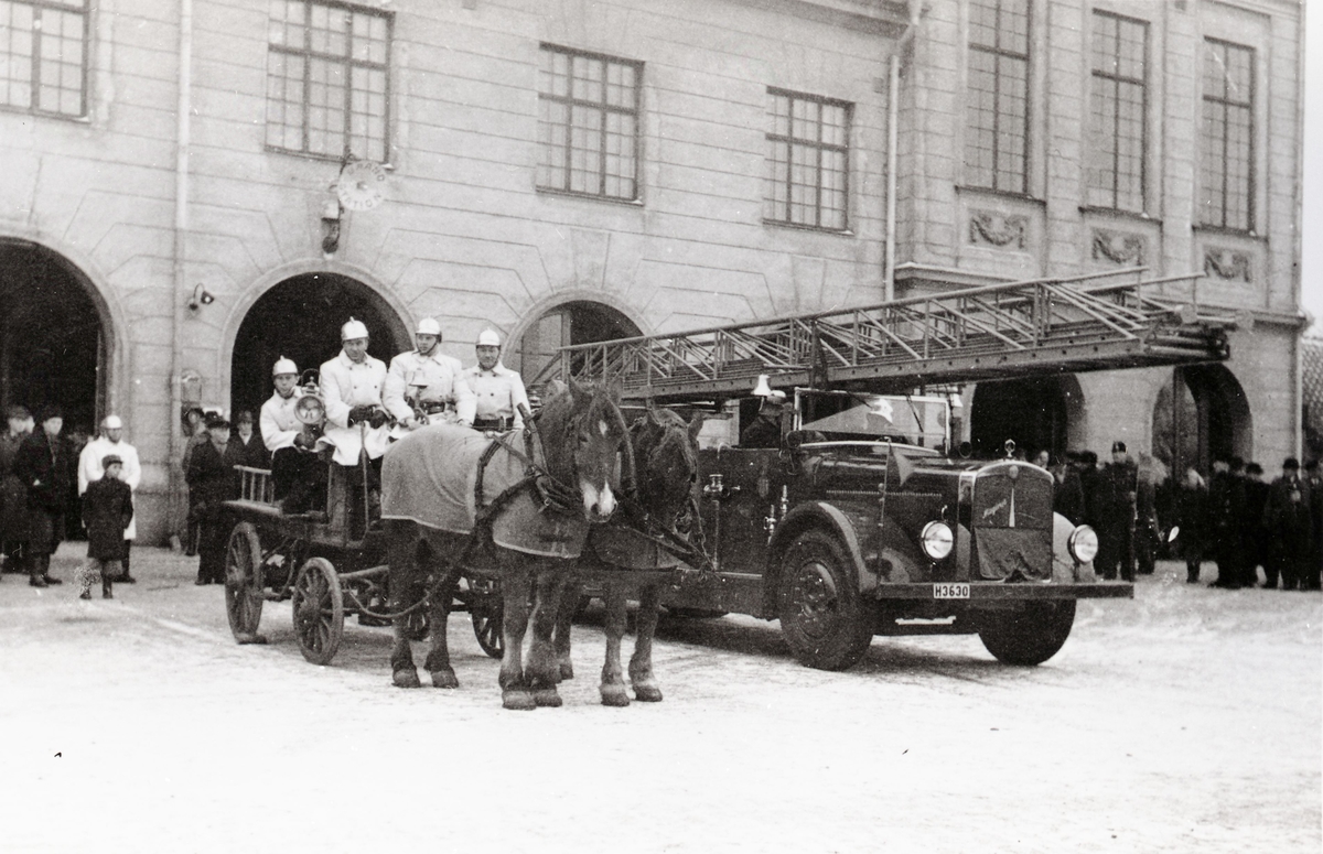 Hästarna Balder och Freja jämte den stora stegbilen utanför brandstationen.