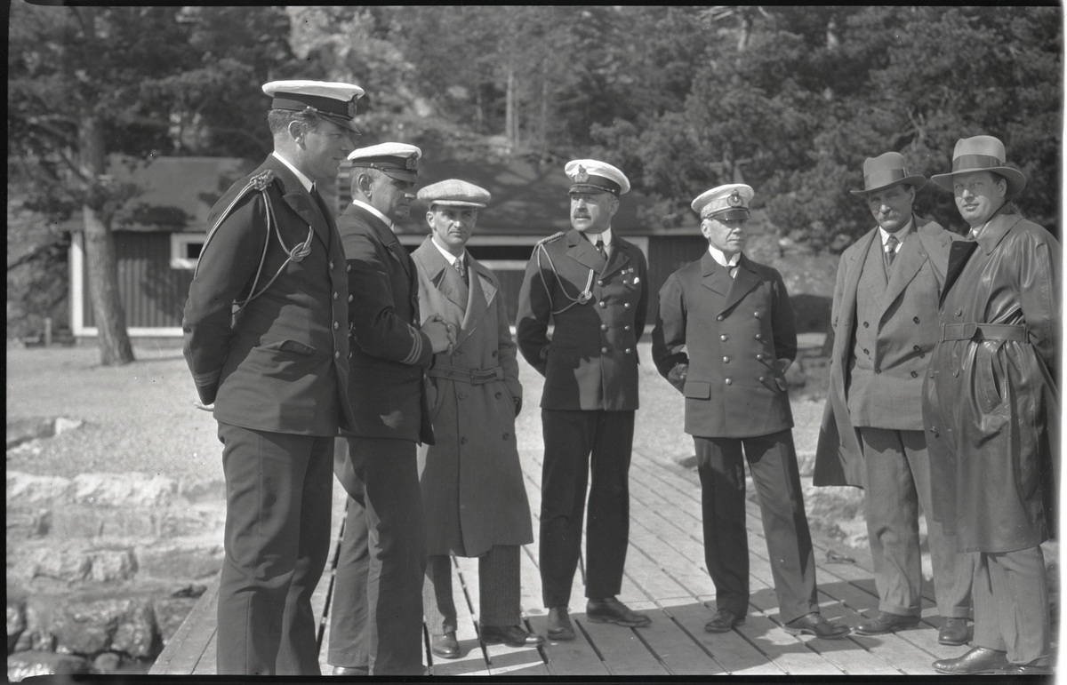 Fyra sjöofficerare och tre civilister på brygga, sammanhanget okänt. De båda officerarna i mitten är till v kommendör Claës Lindsström och till h amiral Harald Åkerman.