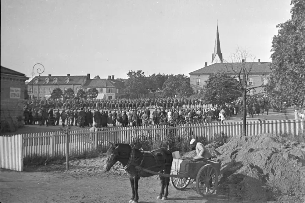 Strandgateparken og Stortorget med hest, kjerre og militærparade.