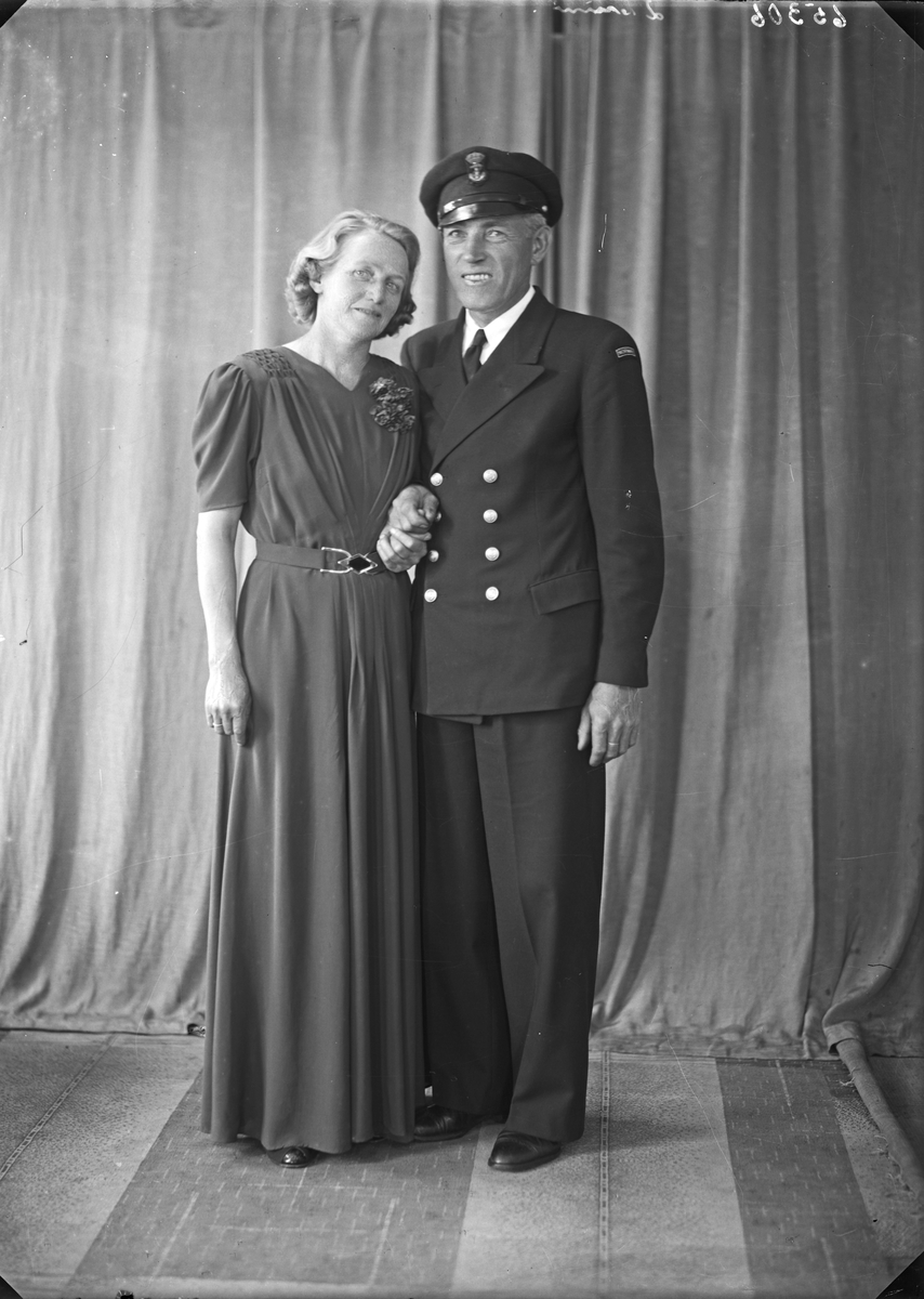 Gruppebilde. Familiegruppe på to. En kvinne og en mann i uniform. Bestillt av Vilh. Larsen.