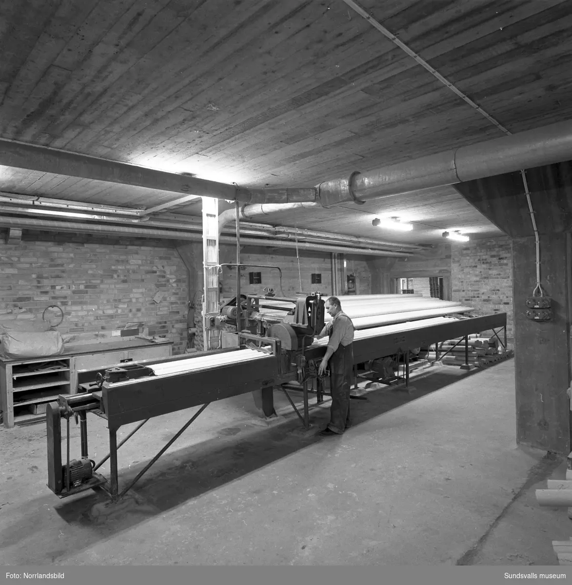 En serie bilder från Ortvikens pappersbruk, exteriörer och interiörer med olika maskiner. Bland annat en transportör från Nordströms linbanor.