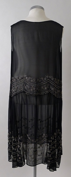 Klänning, av svart georgette. Rikt broderad med ofärgade- och grå pärlor. Rynkad vid axelsömmen. 1920-talet.